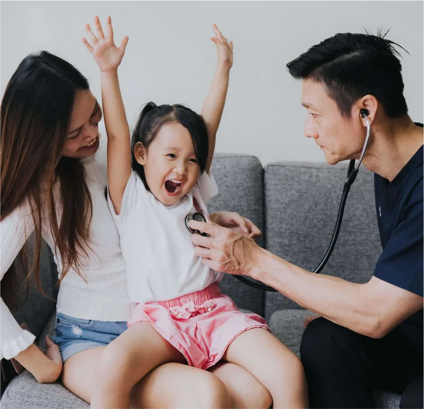 doctor attending to sick child at home with mother